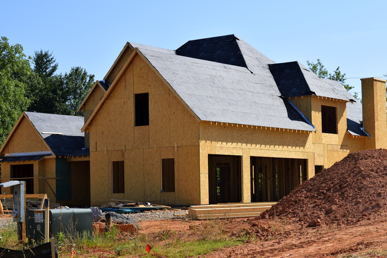why-choose-us A partially built wooden house under construction, showcasing its progress and design in daylight.