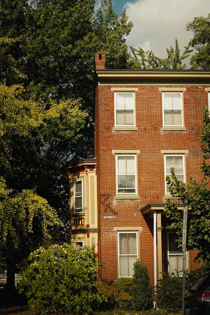Charming red brick building with lush greenery in a tranquil neighborhood.